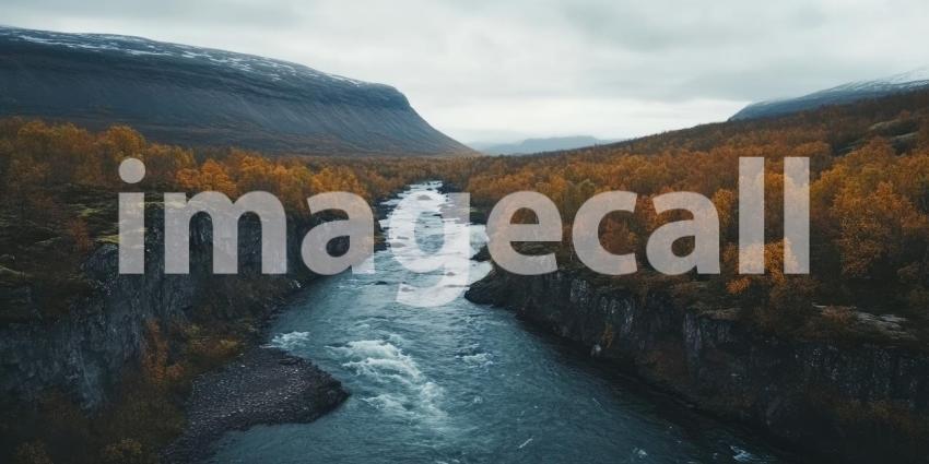 Aerial View of a Serpentine River Flowing Through a Valley of Autumnal Trees, with Snow-capped Mountains in the Distance