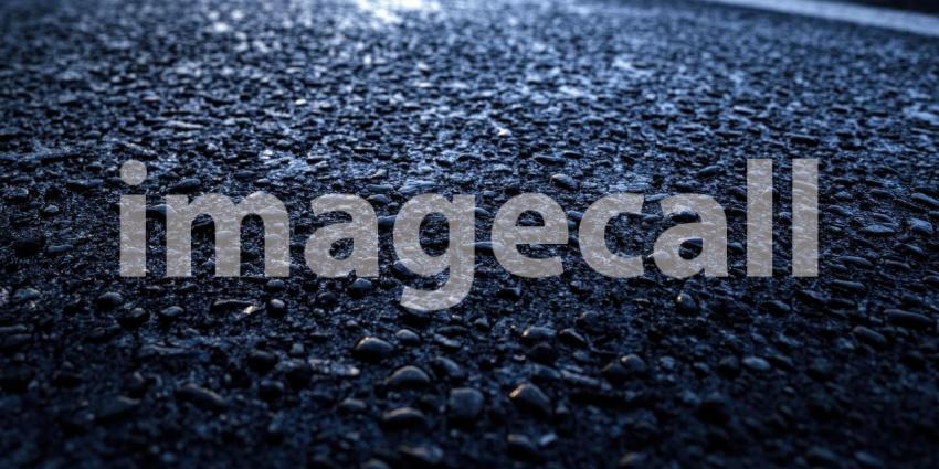 Close-up of a Yellow Line on a Dark Blue Asphalt Road at Night