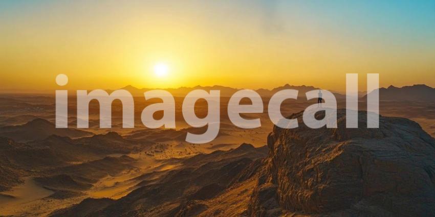 Golden Sunset Over Water Between Rocky Mountains, Dramatic Landscape with Clouds and Reflections