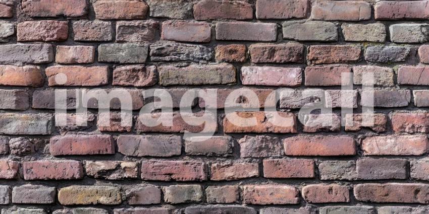 Aged Brick Wall Texture: Varied Colors and Weathered Surfaces, Close-Up of Rustic Construction Material in a Patterned, Time-Worn Detail.