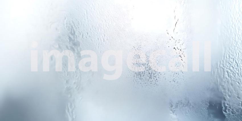 Water Runs Down a Glass Surface Distorting the View in an Abstract Dance of Light and Texture