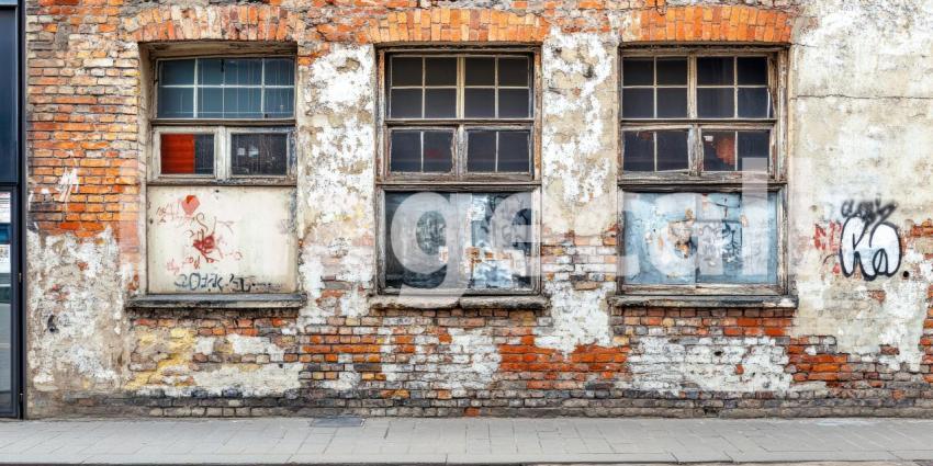 Weathered Facade with Distressed Windows: A Glimpse of Urban Decay and Industrial History