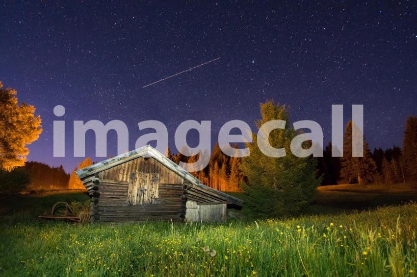 Wooden barn under a starry sky
